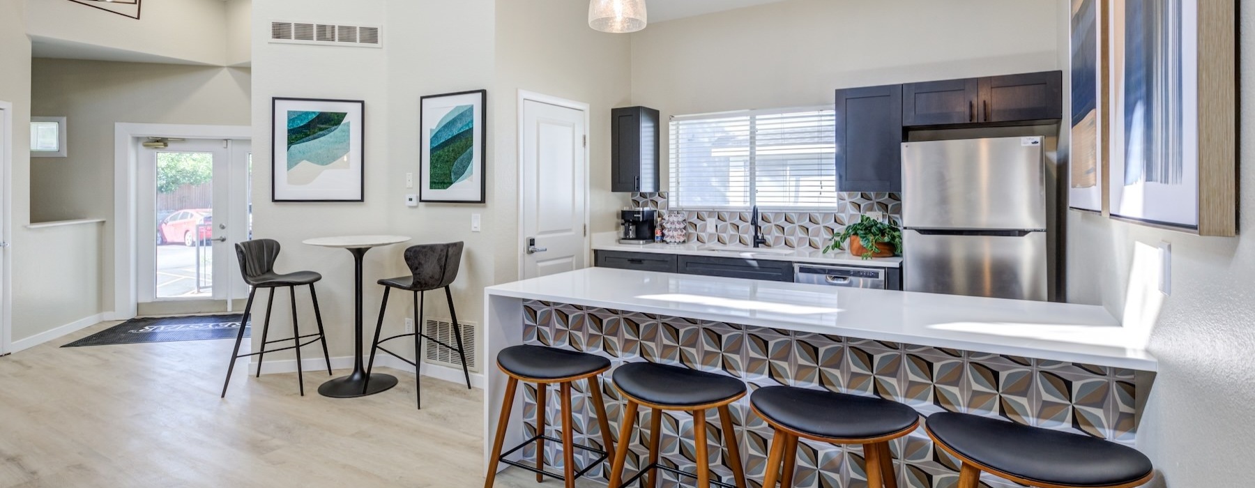 a kitchen with stools and a bar