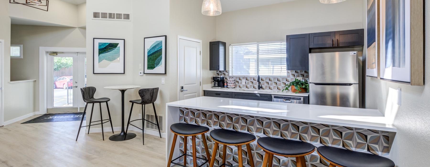 a kitchen with stools and a bar